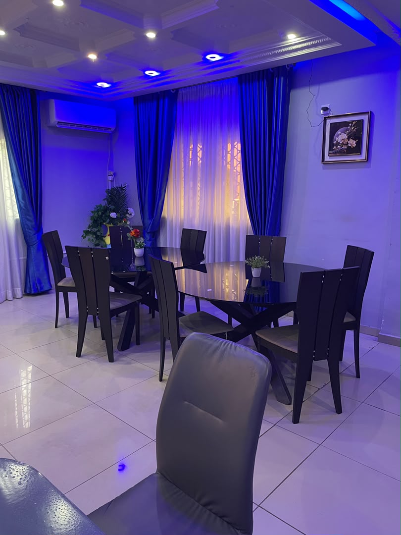 Salle à manger intérieure climatisée, grande table ovale de huit couverts sous un éclairage bleu